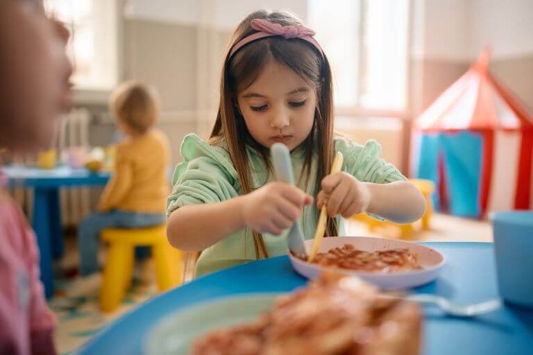 Dziewczynka jedząca obiad w przedszkolu